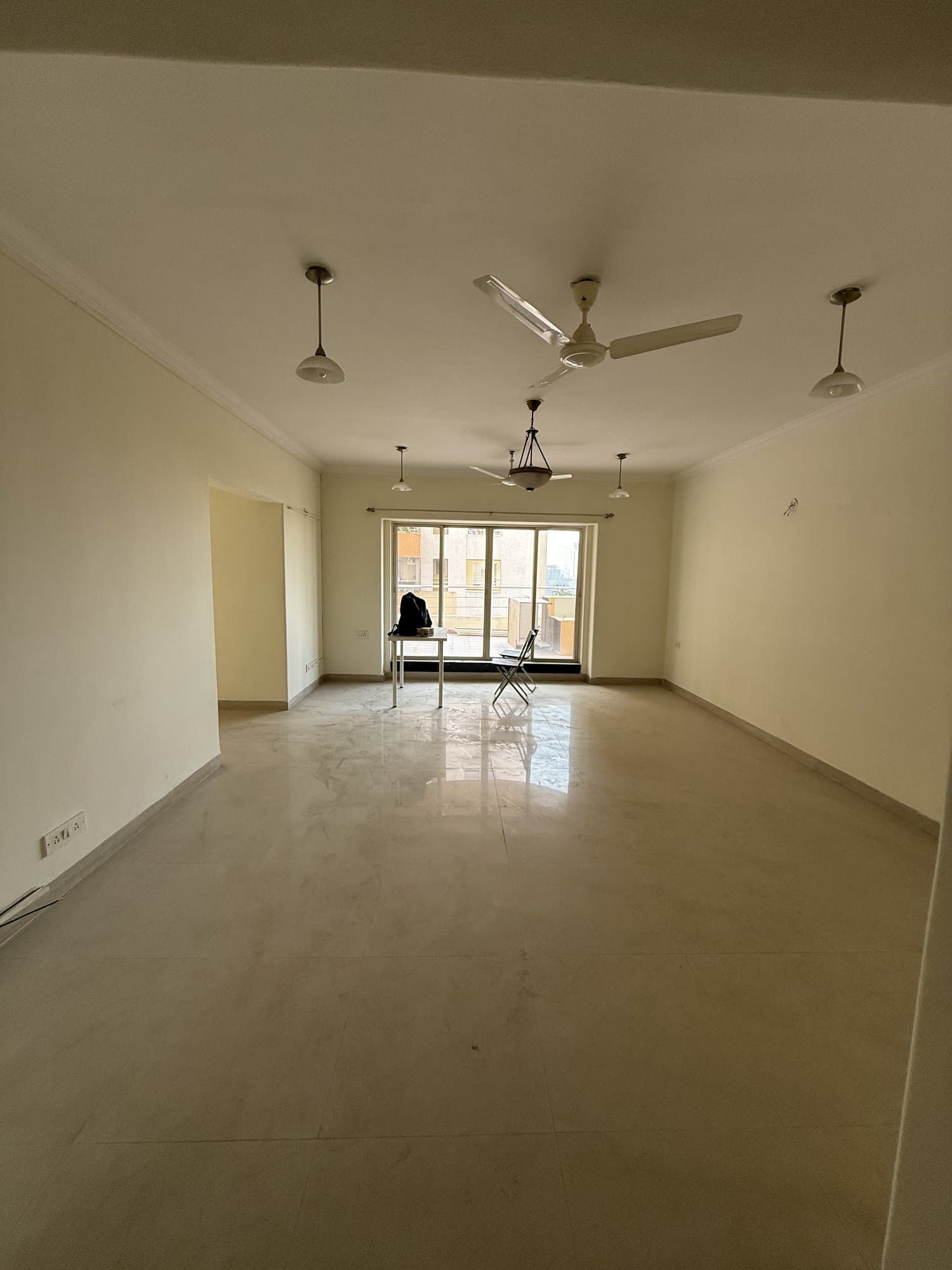 The existing living room before renovation — an empty, unfurnished room