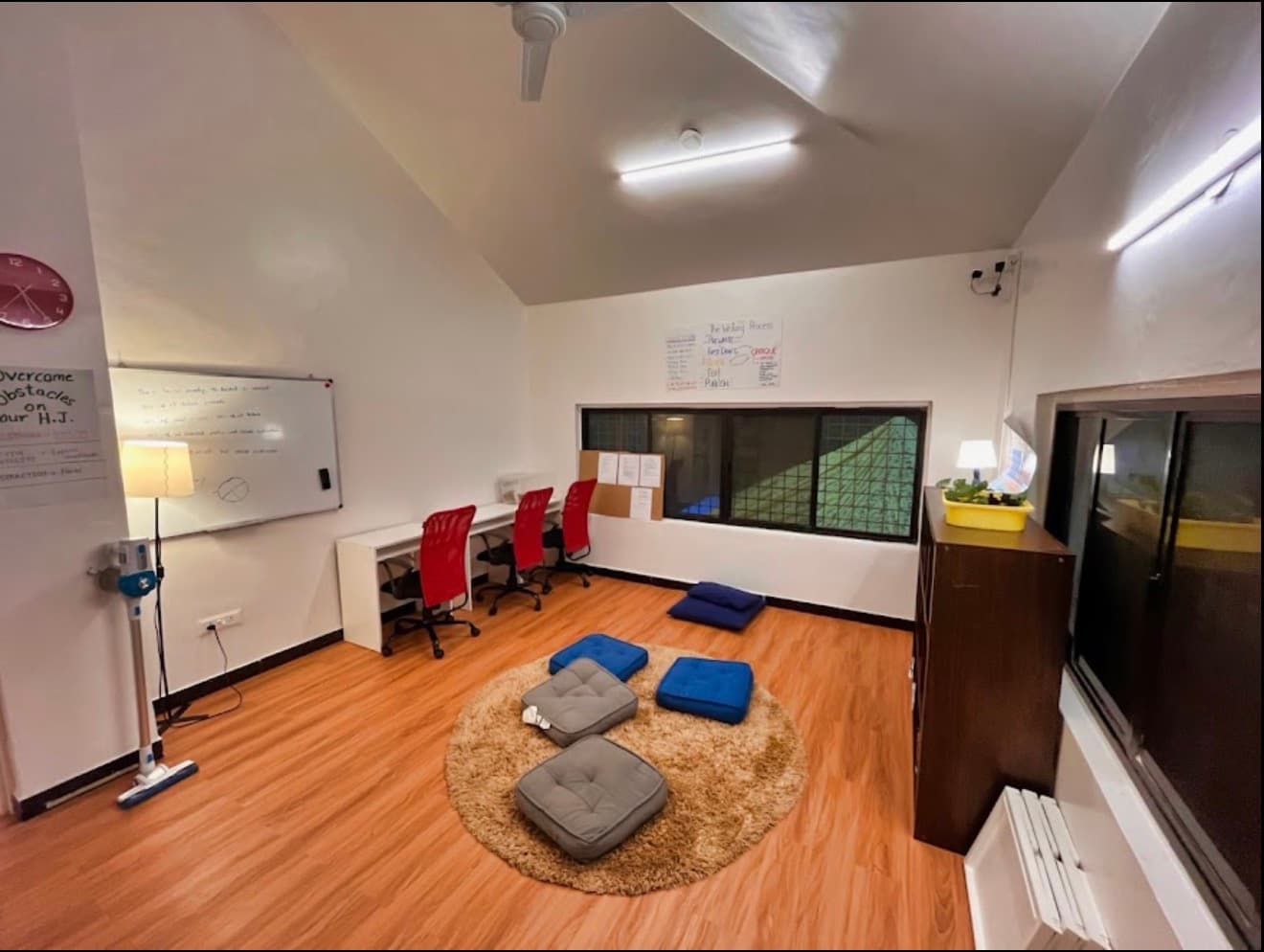 A discussion room at the school, with a whiteboard, floor cushions and seating arranged in a circle