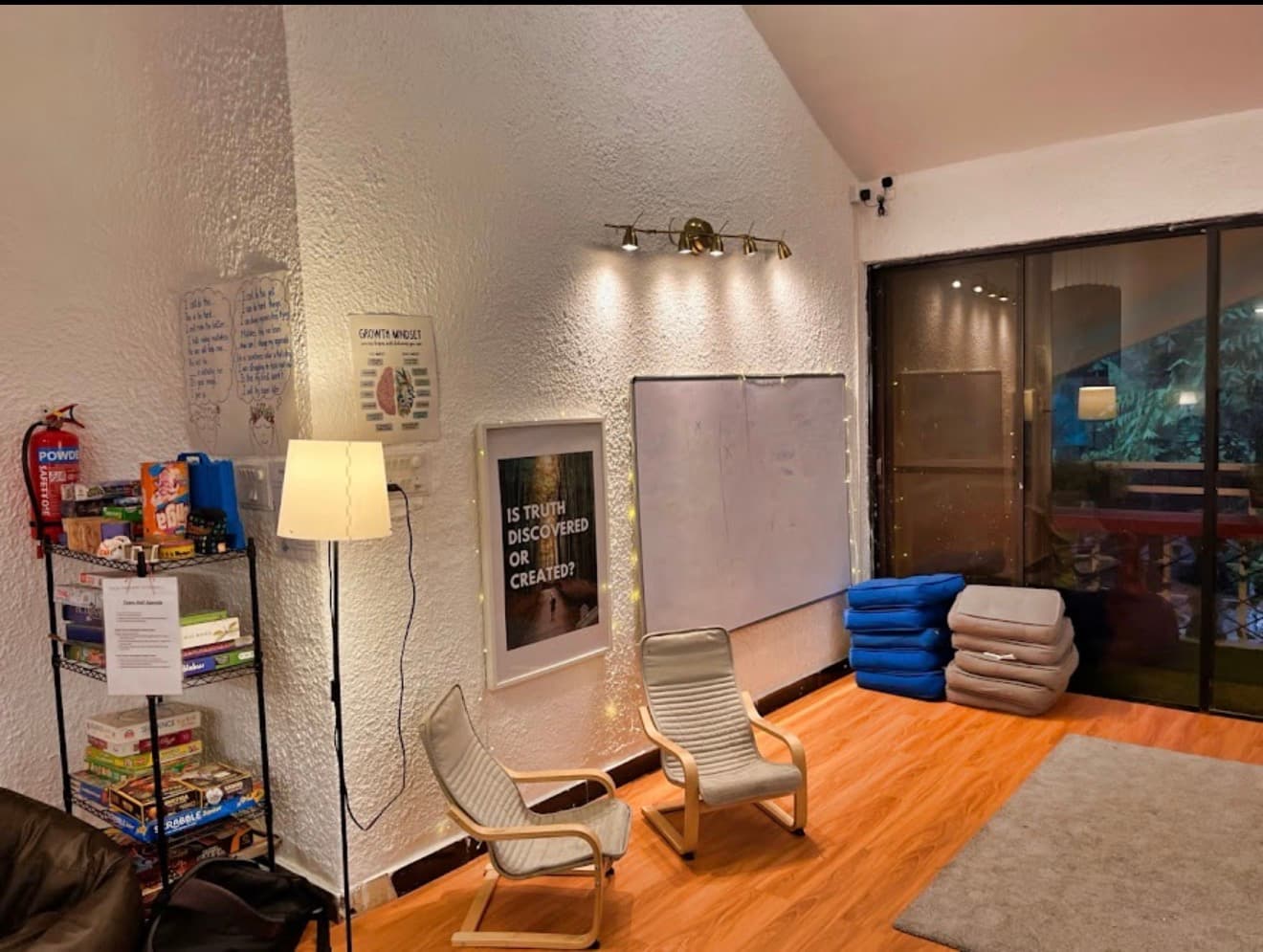 A reading and games lounge at the school, with board games, a growth-mindset poster and floor seating