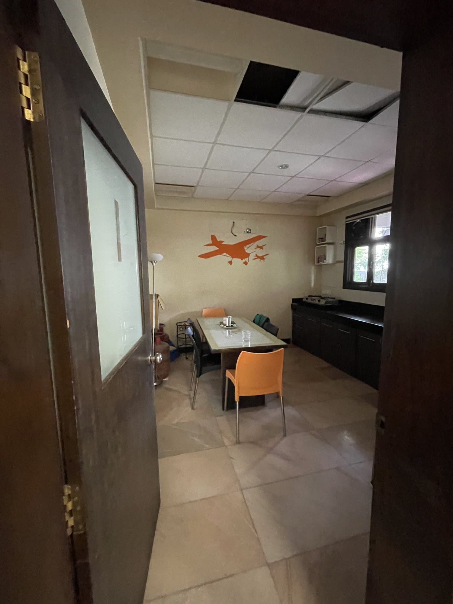 The existing pantry/dining area before renovation, with a wall mural and basic furniture