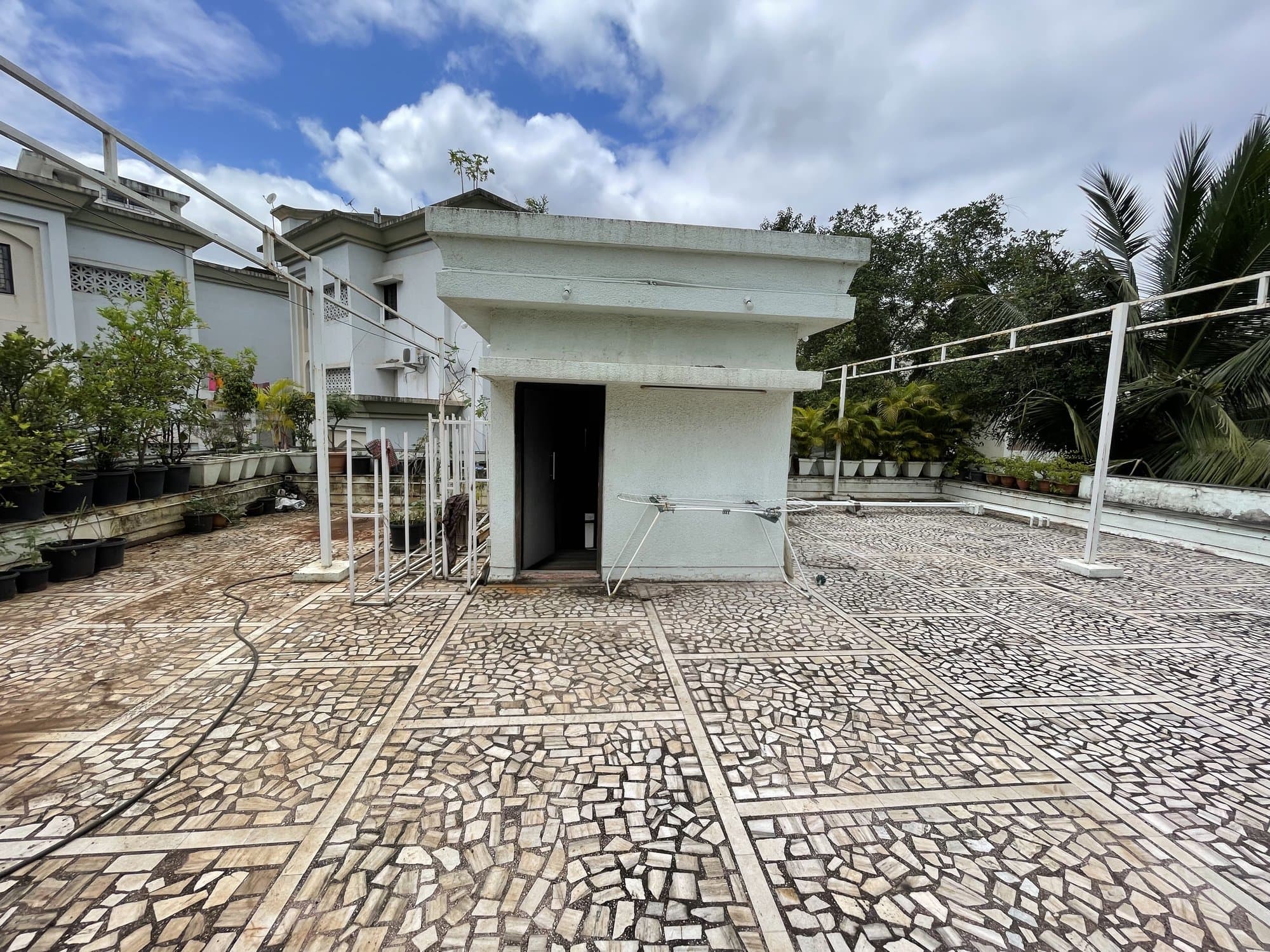 The existing rooftop terrace before renovation — an undeveloped tiled area with a small utility room